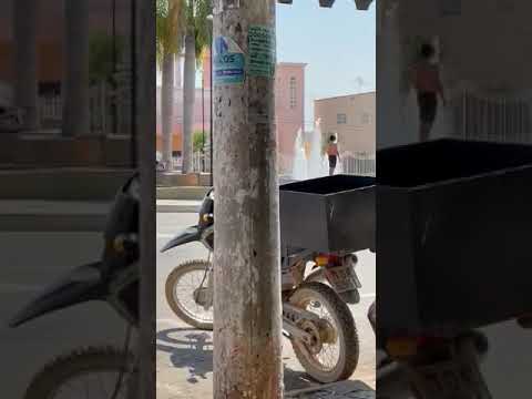 Homens usam fonte da praça para se refrescarem do calorão do final de semana em João Pinheiro