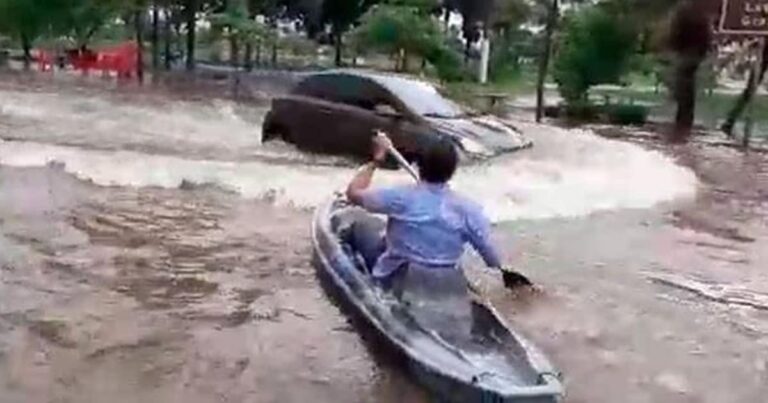 Após temporal, morador se diverte com caiaque em rua alagada de Patos de Minas